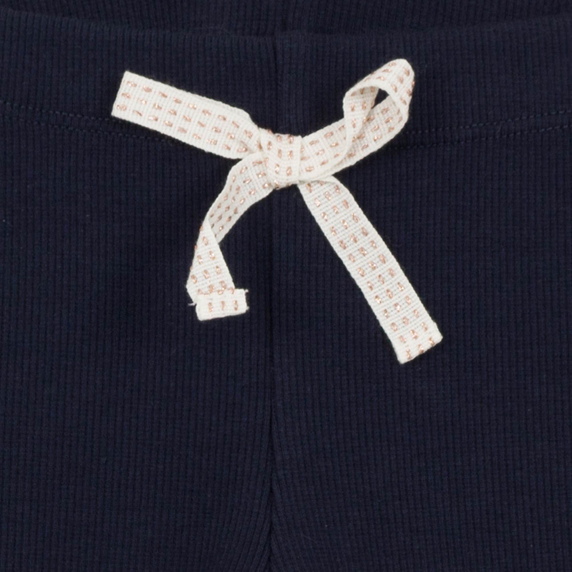Jean Bourgert navy blue cotton leggings is punctuated by fine ribs and large ivory ribbon at the waist.