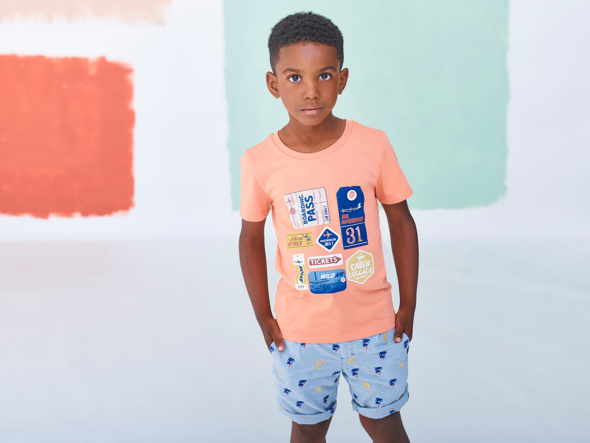 Jean Bourget light blue chambray bermuda shorts are embroidered with yellow camels and blue and orange palm trees all over.