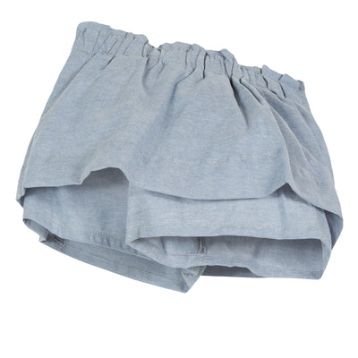 Light blue chambray skort is animated with elegant flat pleats on the waist, bringing a puffing effect to the silhouette. Designed by Jean Bourget.