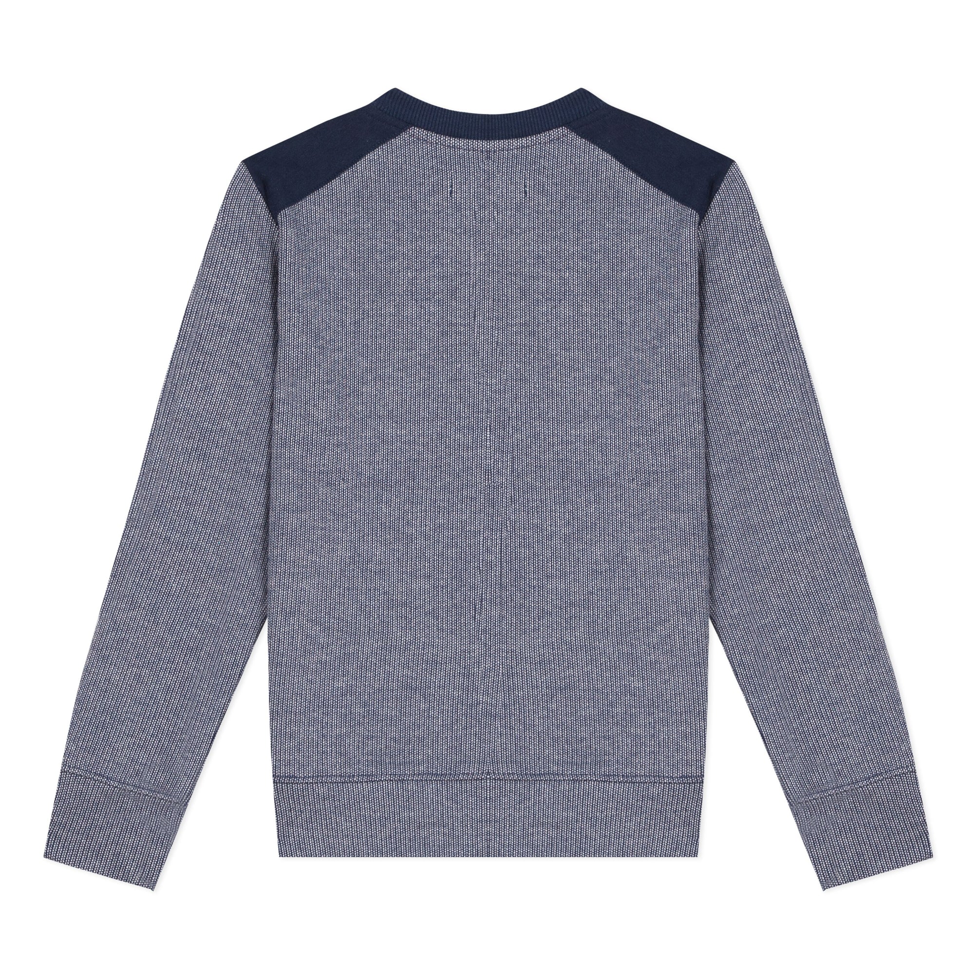 Jean Bourget classic knit in mottled indigo wool with round neck and long sleeves features denim blue cuffs and trimmed waist and a pocket sewn in front.