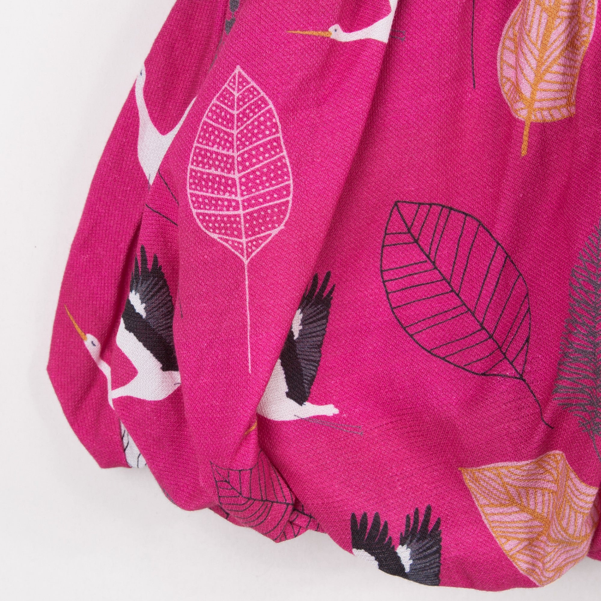 Catimini short bubble skirt in fuchsia with a stork print on a crepe lined bottom and elastic waistband.