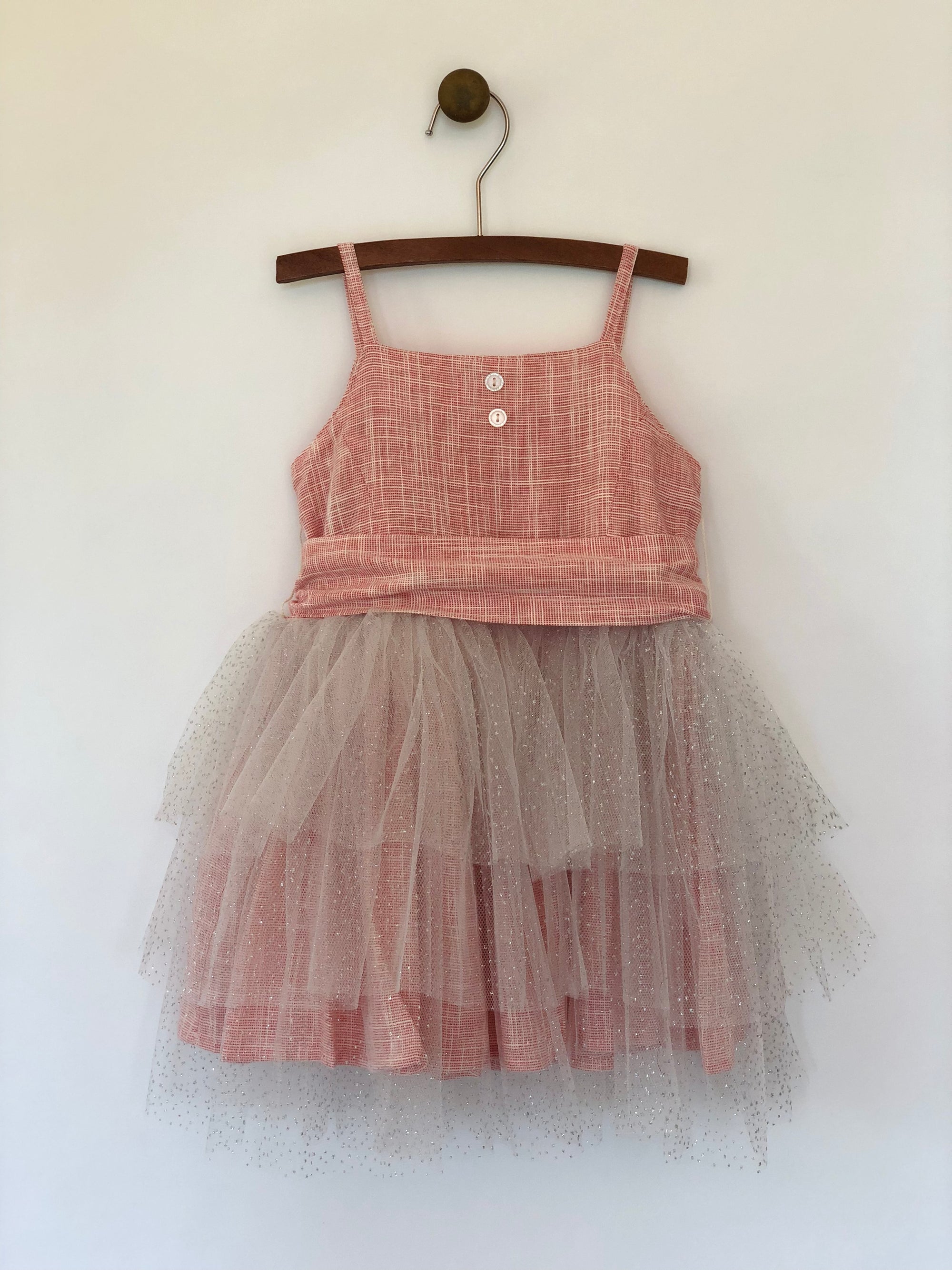 Girls rouge color tulle dress with large wrap around bow and straps. This dress is by Vignette.