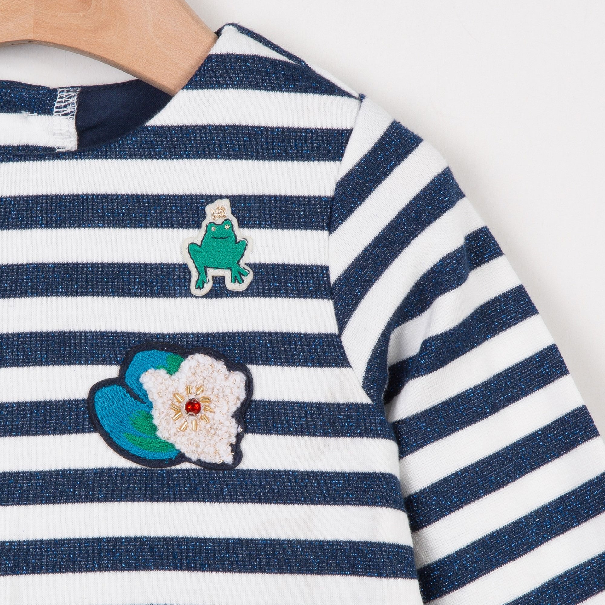 Long sleeve knit dress with glittering metallic stripes and small fairytale patches on the chest. Round neckline and sequinned buttons on the back. Catimini design.