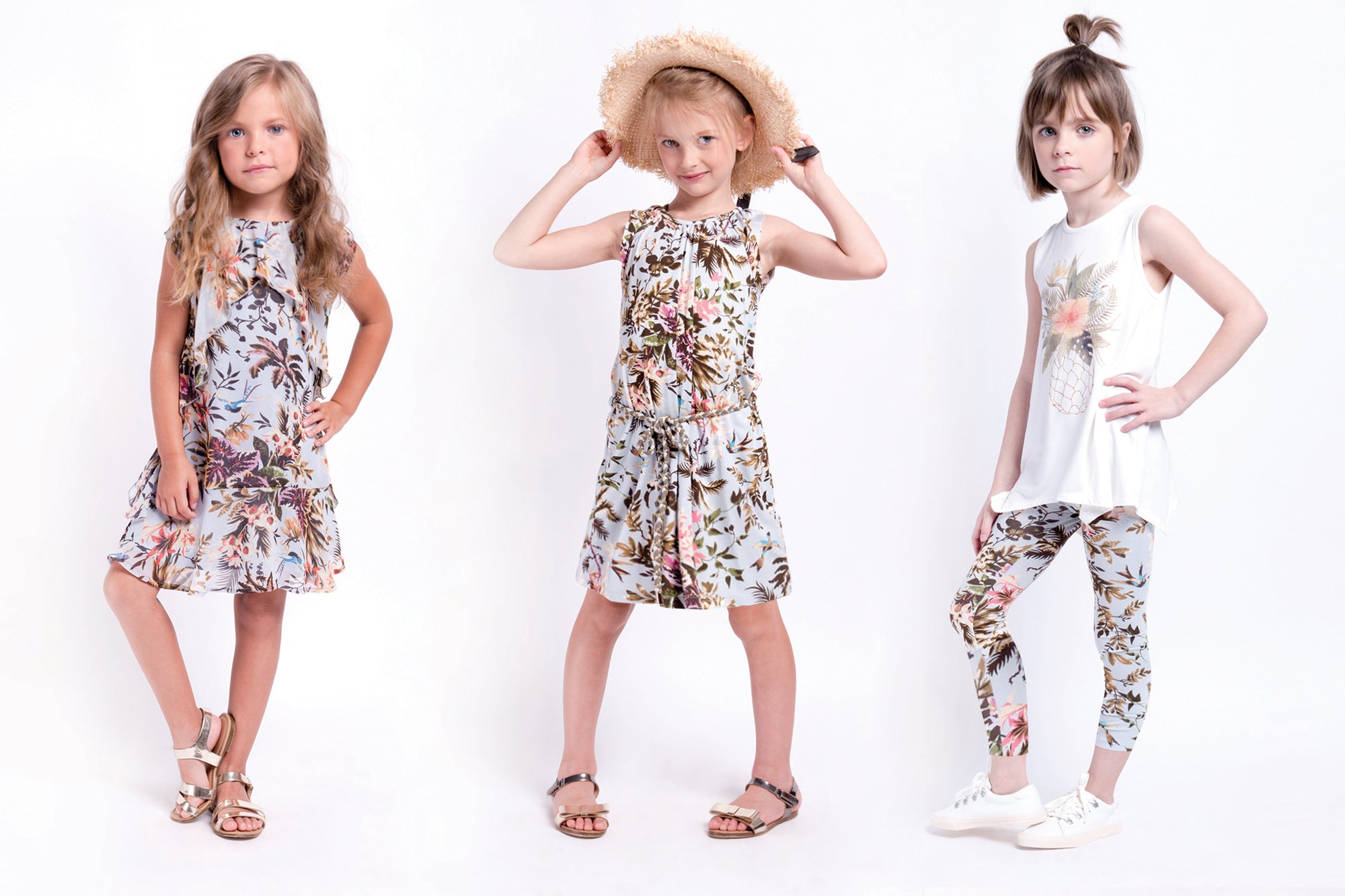 Girls tropical print summer dress with braided straps. Palm trees and hummingbirds are the main focus of this dress. Made with lightweight jersey material this dress is by Imoga.