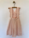 Girls blush color overalls with ruffled straps down the back. 100% cotton. Shop Vignette today.